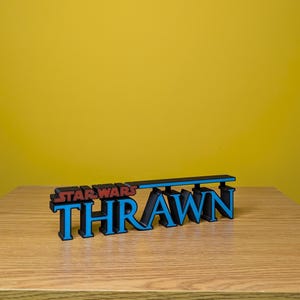 May include: A blue and black 3D printed sign that reads "Star Wars Thrawn".