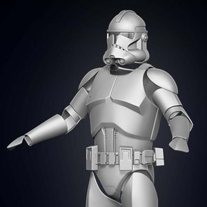 May include: A white plastic model of a Star Wars clone trooper. The figure is wearing a helmet and armour, and is posed in a standing position with one arm extended.