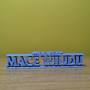 May include: A blue 3D printed sign that reads "STAR WARS MACE WINDU".