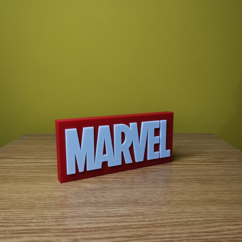 May include: A red rectangular sign with the word "MARVEL" in white raised letters.
