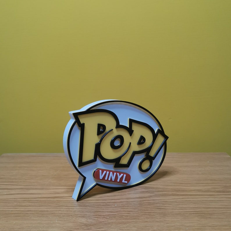 May include: White and yellow 3D Pop! Vinyl logo with a speech bubble and the text "Pop! Vinyl" in a red rectangle.