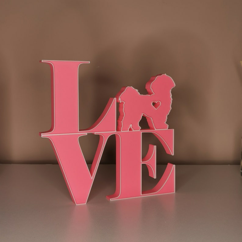 May include: Pink wooden "LOVE" sign with a silhouette of a dog in the center of the "O".