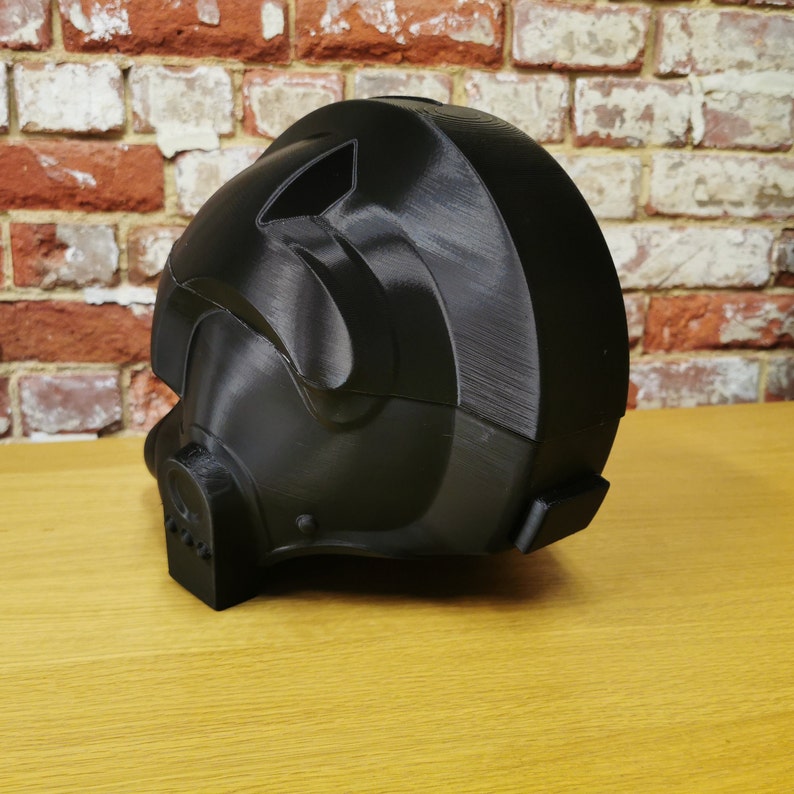 May include: A black 3D printed helmet with a detailed design. The helmet has a visor and a chin guard.