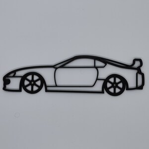 May include: A black line drawing of a sports car with a spoiler. The car is facing to the right and is in profile view.