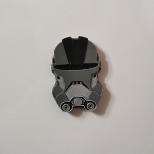 May include: A gray and black 3D printed helmet with a visor and a textured surface.