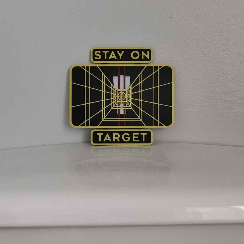 May include: A yellow and black Star Wars themed target sign with the text "Stay on Target".