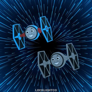 以下が含まれることがあります： スター・ウォーズのTIEファイターのカートゥーンが2機、それぞれトーマスと仲間たちのキャラクターの顔をしたものが、青と黒の宇宙の背景を飛んでいます。