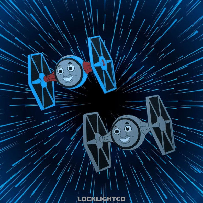 以下が含まれることがあります： スター・ウォーズのTIEファイターのカートゥーンが2機、それぞれトーマスと仲間たちのキャラクターの顔をしたものが、青と黒の宇宙の背景を飛んでいます。