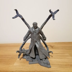 May include: A gray plastic action figure of Doctor Octopus from the Marvel universe. The figure has four mechanical arms and is standing on a gray base.