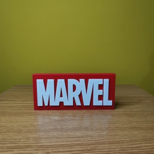 May include: A red rectangular sign with the word "MARVEL" in white letters.