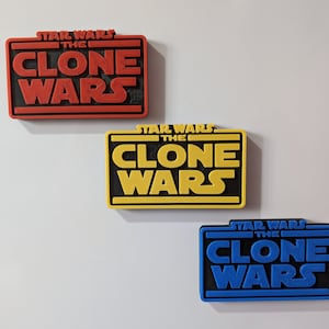 May include: Three 3D printed Star Wars: The Clone Wars logos in red, yellow, and blue.