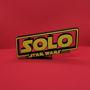 May include: A black and yellow sign with the text "SOLO: A STAR WARS STORY".
