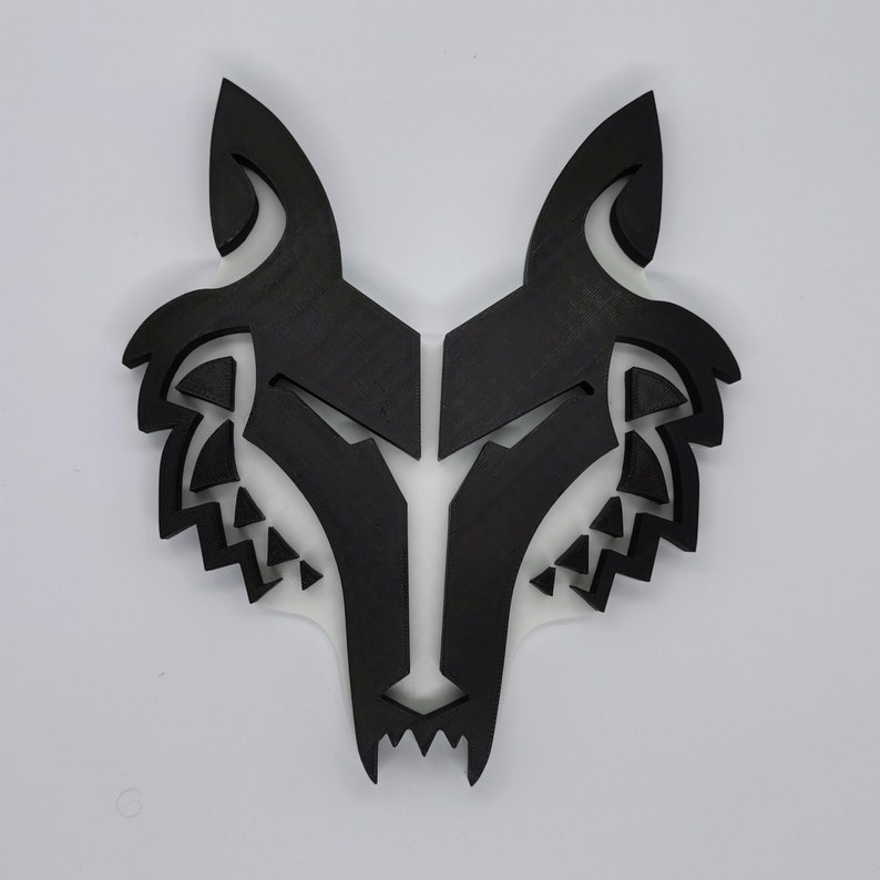 May include: Black wolf head silhouette wall decor. The wolf head is made of wood and has a detailed design.