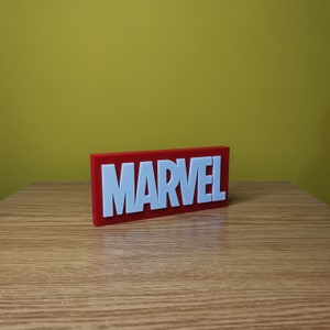 May include: A red rectangular block with the word "MARVEL" in white raised letters.