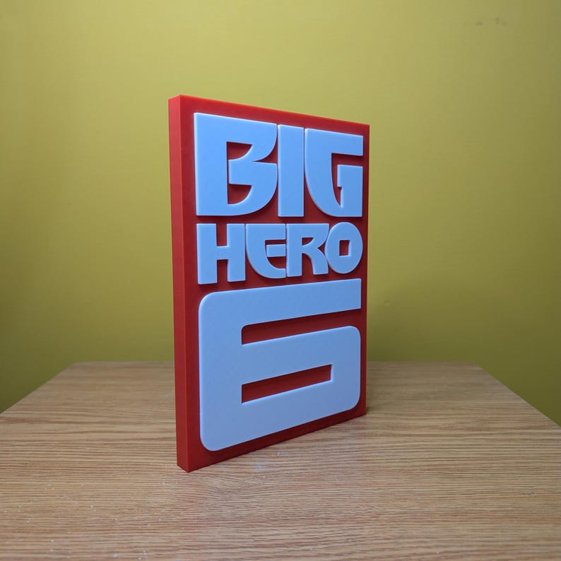 May include: A red and white 3D printed sign with the words "BIG HERO 6" in white letters.