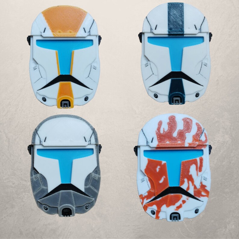 May include: Four different colored plastic helmets with a blue visor. The helmets are white with different colored designs. One helmet is orange, one is black and white, one is gray, and one is orange and white.