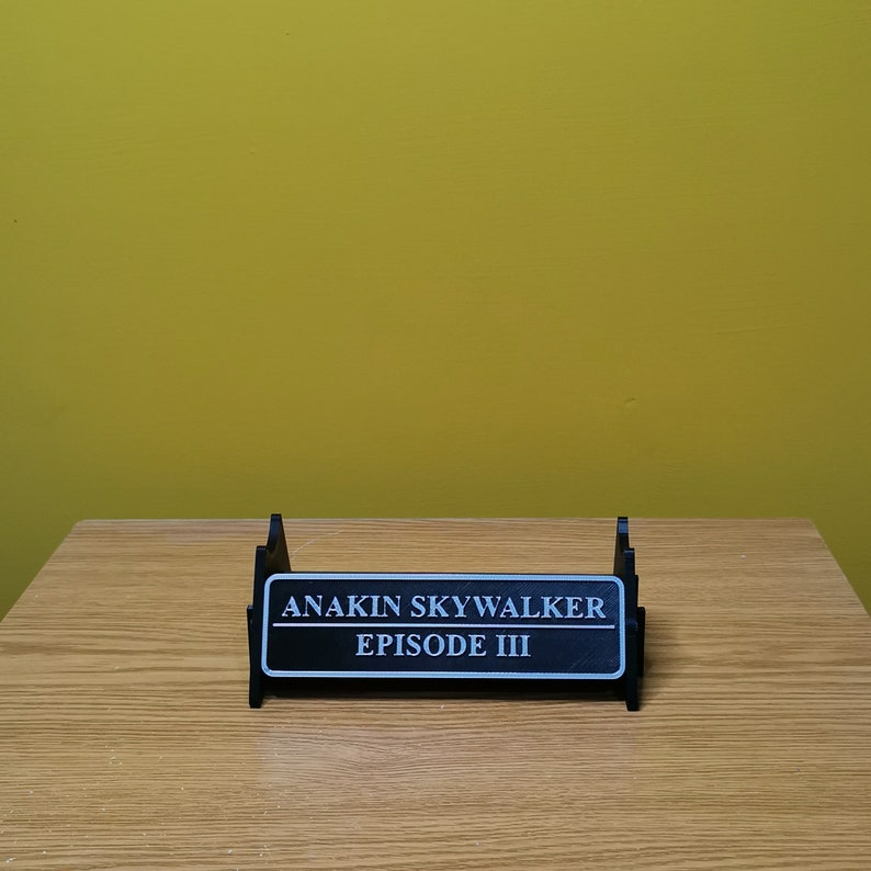 May include: Black plastic stand with a white label that reads "Anakin Skywalker Episode III".