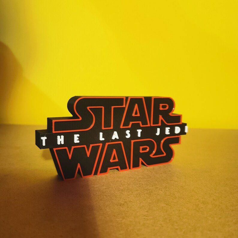May include: Black and red 3D printed Star Wars logo with the text "The Last Jedi" in white.