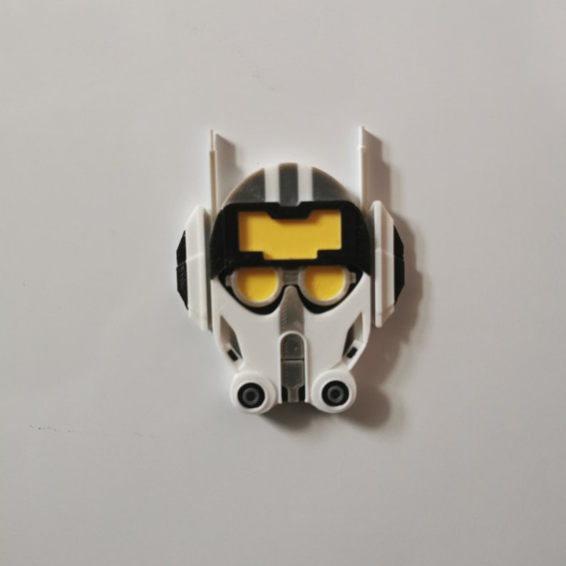 May include: A white and black plastic helmet with yellow accents. The helmet has a visor and two round openings on the bottom.