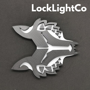 May include: Black and white geometric wolf head design. The design is made of layered shapes and has a sharp, angular look.