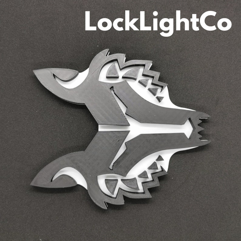 May include: Black and white geometric wolf head design. The design is made of layered shapes and has a sharp, angular look.