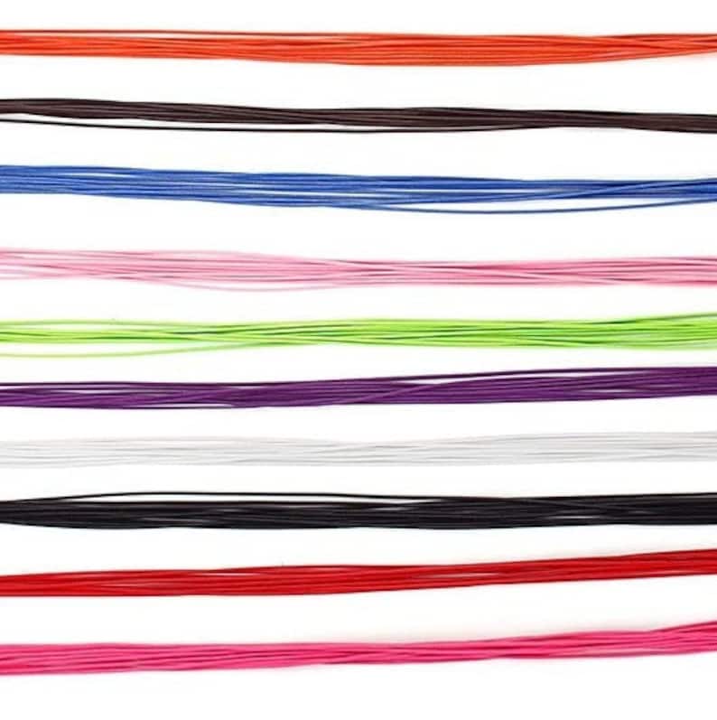 May include: A collection of colorful cords in various shades, including red, orange, brown, blue, pink, green, purple, white, and black. The cords are arranged horizontally against a white background, creating a vibrant and visually appealing display.