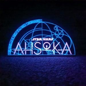 May include: A blue and white neon sign with the text "STAR WARS" and "AHsoka" in a geometric design.