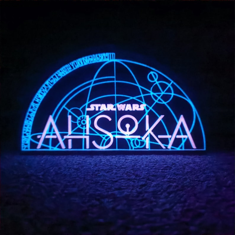 May include: A blue and white neon sign with the text "STAR WARS" and "AHsoka" in a geometric design.