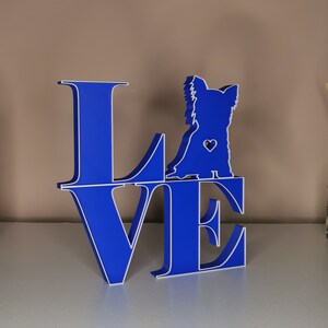 May include: Blue wooden cutout of the word "LOVE" with a silhouette of a Yorkshire Terrier dog in the center of the "O".
