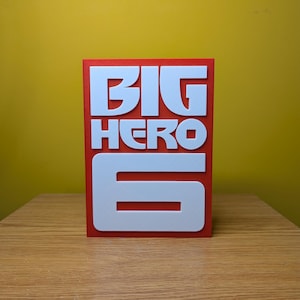 May include: A red card with the words "BIG HERO 6" in white raised letters.