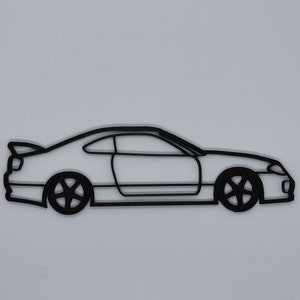 May include: A black line drawing of a car, possibly a sports car, with a side profile view. The car has a rounded front end and a long, sloping hood.