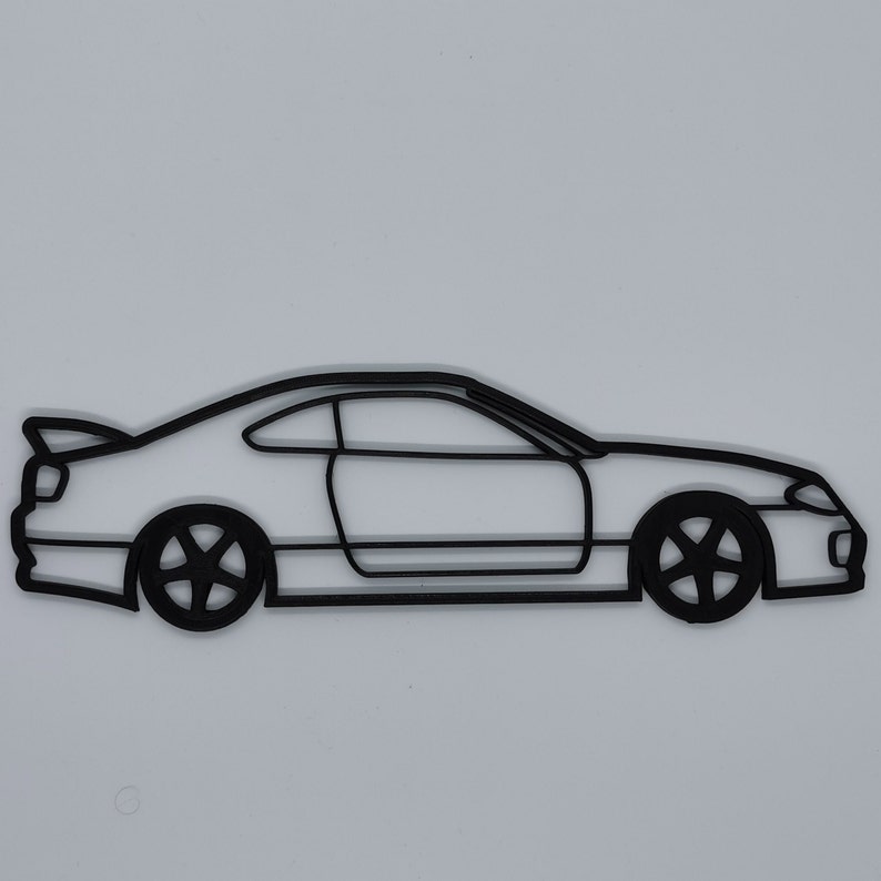 May include: A black line drawing of a car, possibly a sports car, with a side profile view. The car has a rounded front end and a long, sloping hood.