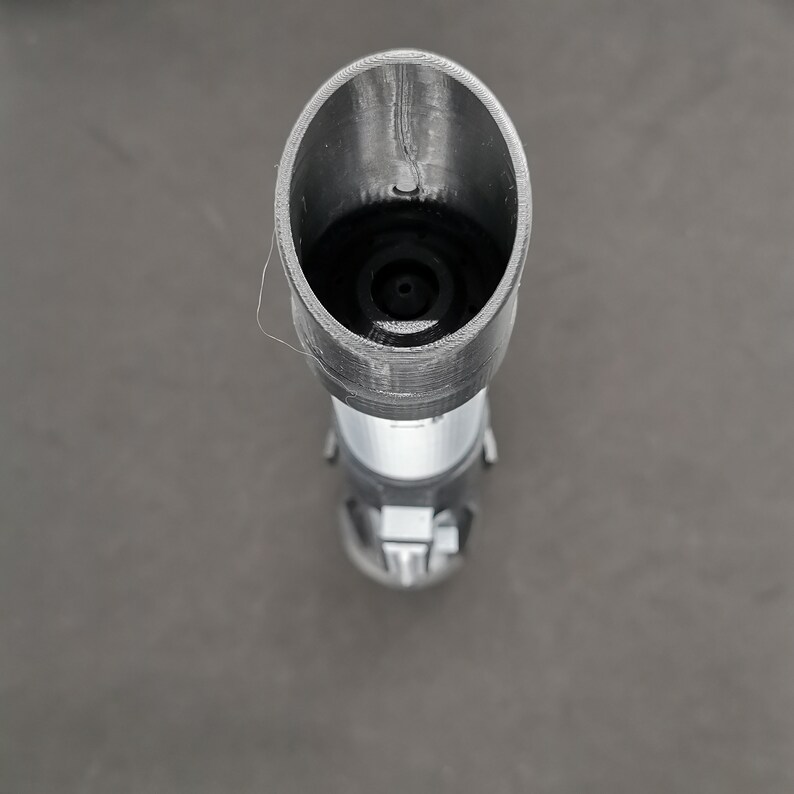 May include: A black and silver lightsaber prop with a black plastic end cap. The lightsaber is a popular collectible for fans of the Star Wars franchise.