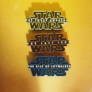 May include: Three Star Wars movie logos, each with a different subtitle. The top logo is yellow and says "STAR WARS THE FORCE AWAKENS". The middle logo is orange and says "STAR WARS THE LAST JEDI". The bottom logo is blue and says "STAR WARS THE RISE OF SKYWALKER".