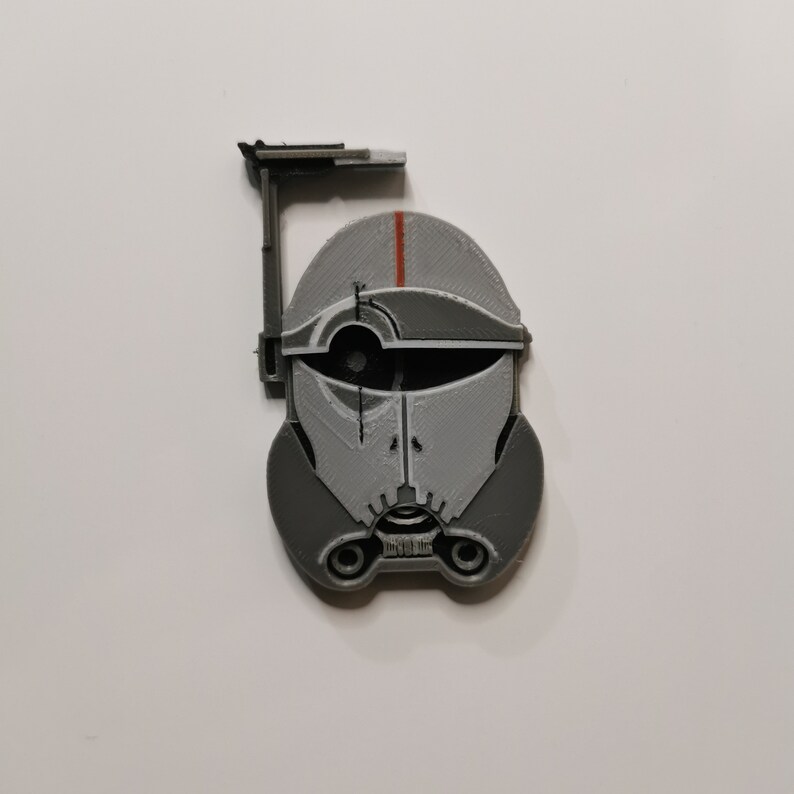May include: A gray and white 3D printed helmet with a red stripe and a black visor. The helmet has a small antenna on top.