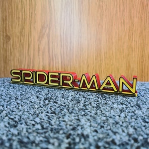 May include: A red and yellow 3D plastic sign that reads "SPIDER-MAN".