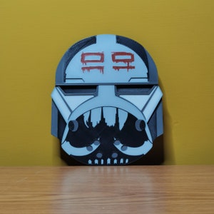 Pu&ograve; includere: Un casco stampato in 3D bianco e nero con un "99" rosso dipinto sul davanti. Il casco ha un design bianco e nero sul fondo.