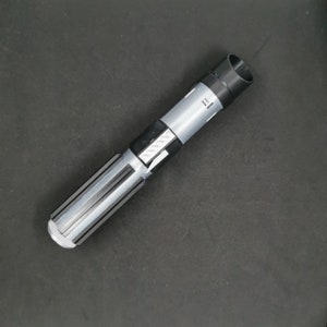 May include: A black and silver lightsaber toy with a textured handle and a black cap on the end.