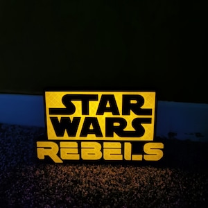 May include: A black and yellow sign with the text "Star Wars Rebels" on it.
