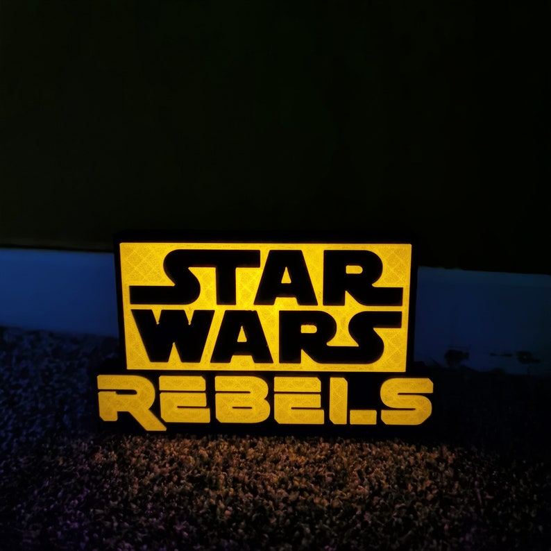 May include: A black and yellow sign with the text "Star Wars Rebels" on it.
