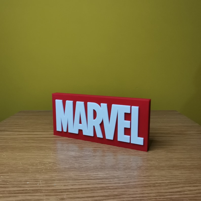 May include: A red rectangular sign with the word "MARVEL" in white raised letters.
