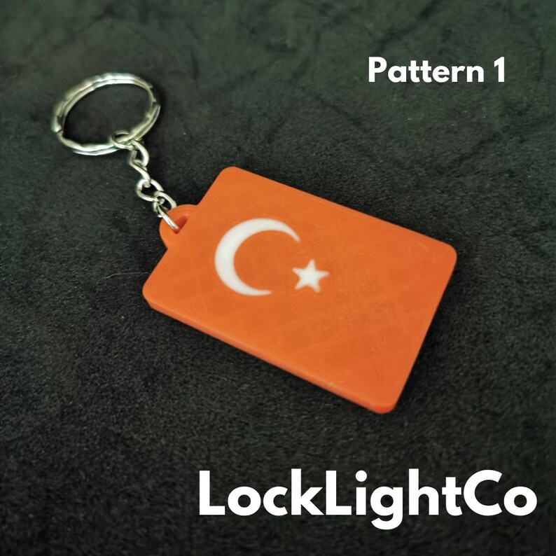 May include: Orange keychain with a white crescent moon and star design. The keychain is labeled "Pattern 1" and "LockLightCo".