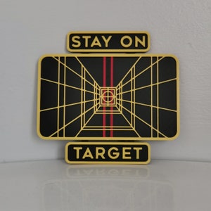 May include: A yellow and black graphic with the text "Stay on Target" in a yellow rectangle at the top and a yellow rectangle at the bottom with the text "Target". The graphic is a black and white image of a grid pattern with red lines in the center.