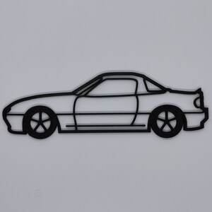 May include: A black line drawing of a car, a coupe, with a rounded roofline and a side profile view.