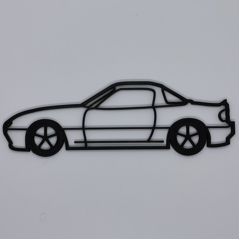 May include: A black line drawing of a car, a coupe, with a rounded roofline and a side profile view.