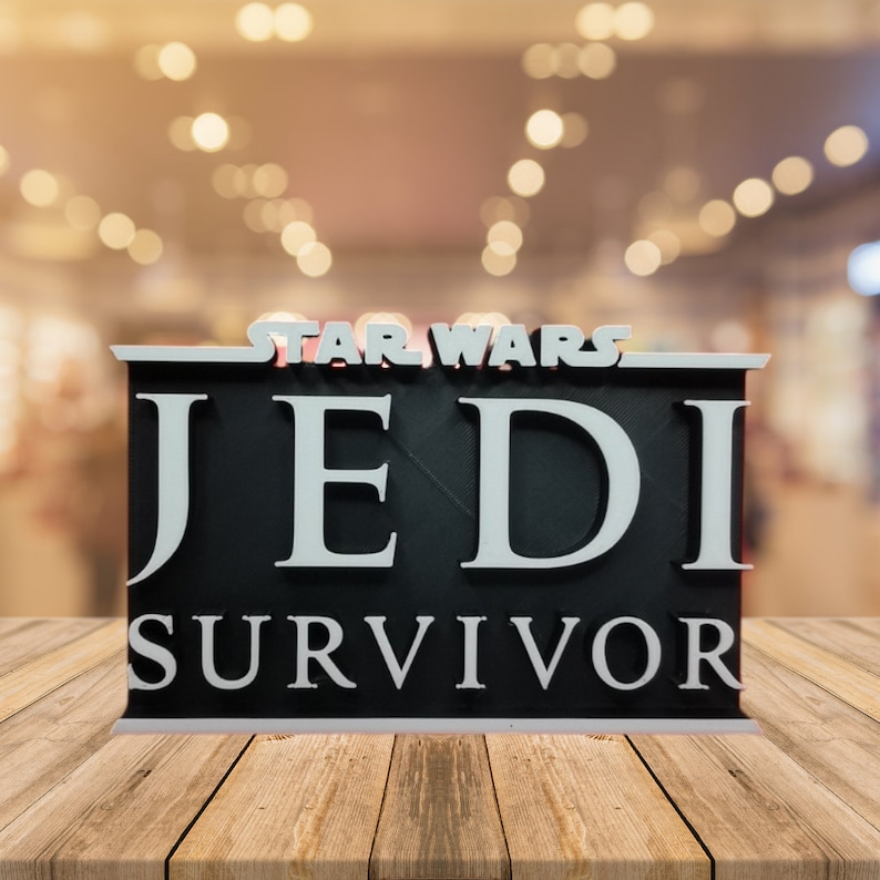 May include: A black and white 3D printed sign with the text "STAR WARS JEDI SURVIVOR" in white letters on a black background.