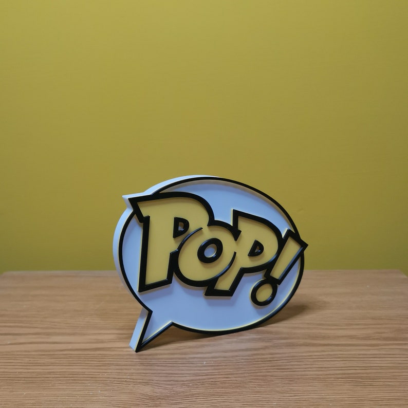 May include: A white speech bubble with a black outline and the word "POP!" in yellow letters.