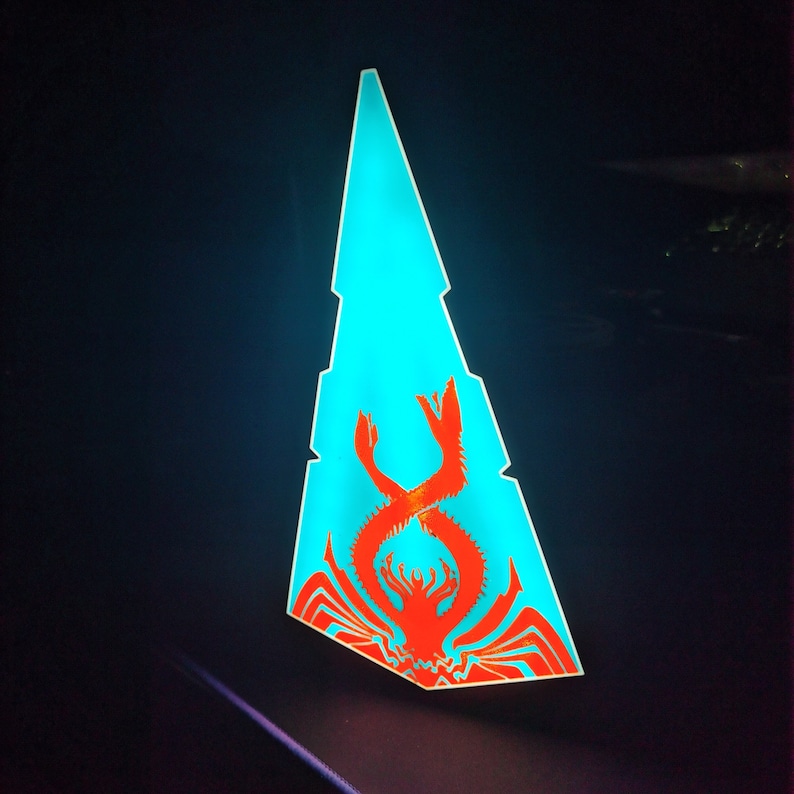 May include: A blue and red triangular shaped light with a red crab design.