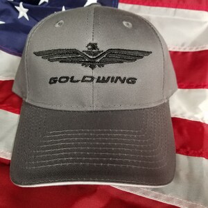 May include: A gray baseball cap with a black embroidered eagle and the text "GOLD WING".