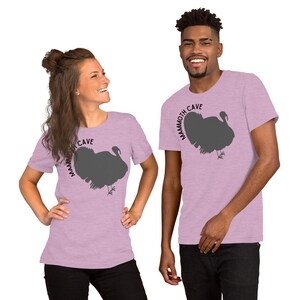 May include: Two people wearing heather purple t-shirts with a silhouette of a turkey and the text "Mammoth Cave" printed on the front.